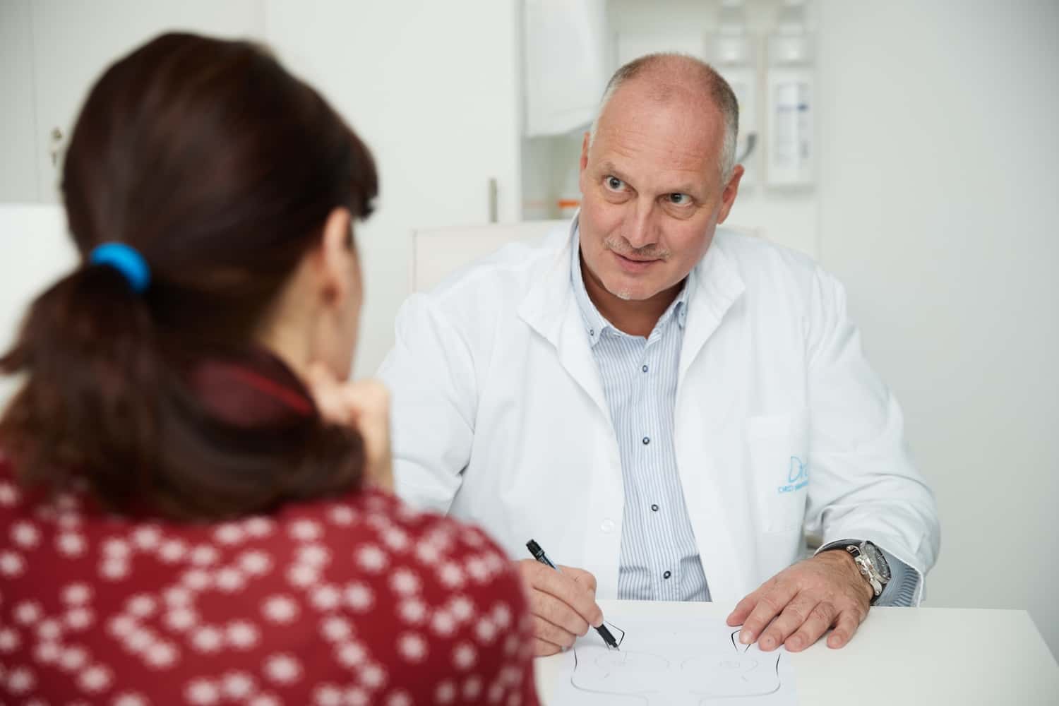 Plasztikai sebész pácienst tájékoztat